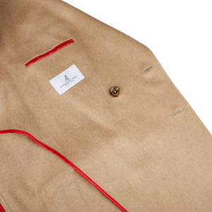An Alexander Kraft Monte Carlo Camel Beige Pure Cashmere Florence DB Overcoat with a red lining.