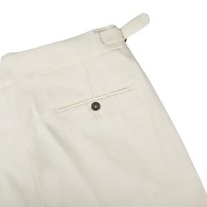 A close-up of Alexander Kraft Monte Carlo Cream White Cotton Twill Updated Gurkha Trousers with buttons, perfect for formal attire.