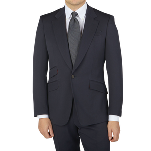 A man is posing in a Navy Blue Textured Worsted Wool Signature Jacket by Alexander Kraft Monte Carlo, wearing a suit and tie.