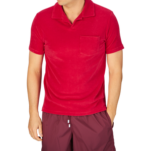 Man in an Altea coral red cotton towelling Capri collar polo shirt and dark shorts.