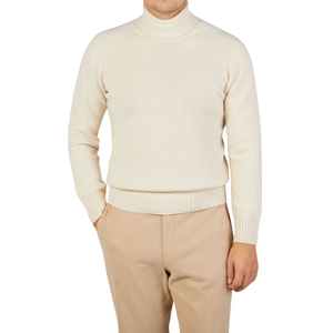 A man wearing an Altea Cream Beige Wool Cashmere Rollneck sweater and tan pants.