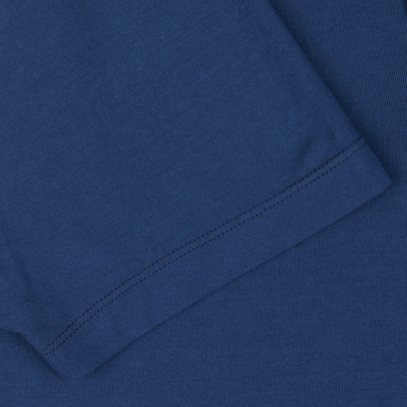 Close-up of a dark blue Altea cotton jersey capri collar polo shirt fabric texture with visible seam stitches.