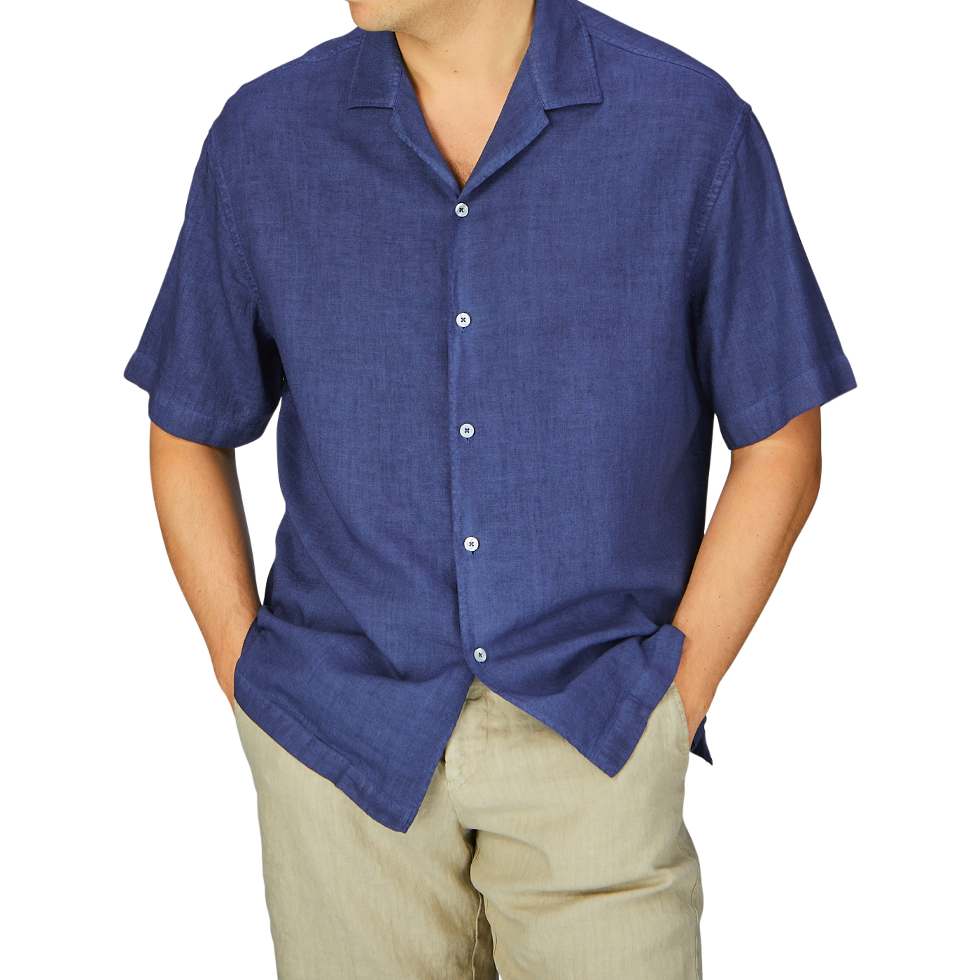 Man in a Dark Blue Linen Blend Open Collar Shirt and beige pants with hands in pockets, embodying a summer essential look by Altea.