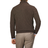 Man standing with his back to the camera, wearing an Altea Dark Brown Shetland Wool Button Cardigan and light brown pants.