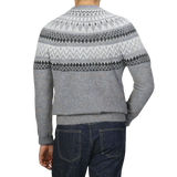 A person wearing an Altea Grey Melange Norwegian Wool Alpaca Crewneck sweater paired with dark blue jeans, seen from the back.