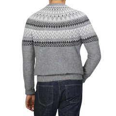 A person wearing an Altea Grey Melange Norwegian Wool Alpaca Crewneck sweater paired with dark blue jeans, seen from the back.