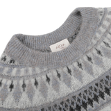 Close-up of a grey melange Norwegian wool-alpaca blend crewneck with a geometric pattern and a tag reading "Altea Milano".