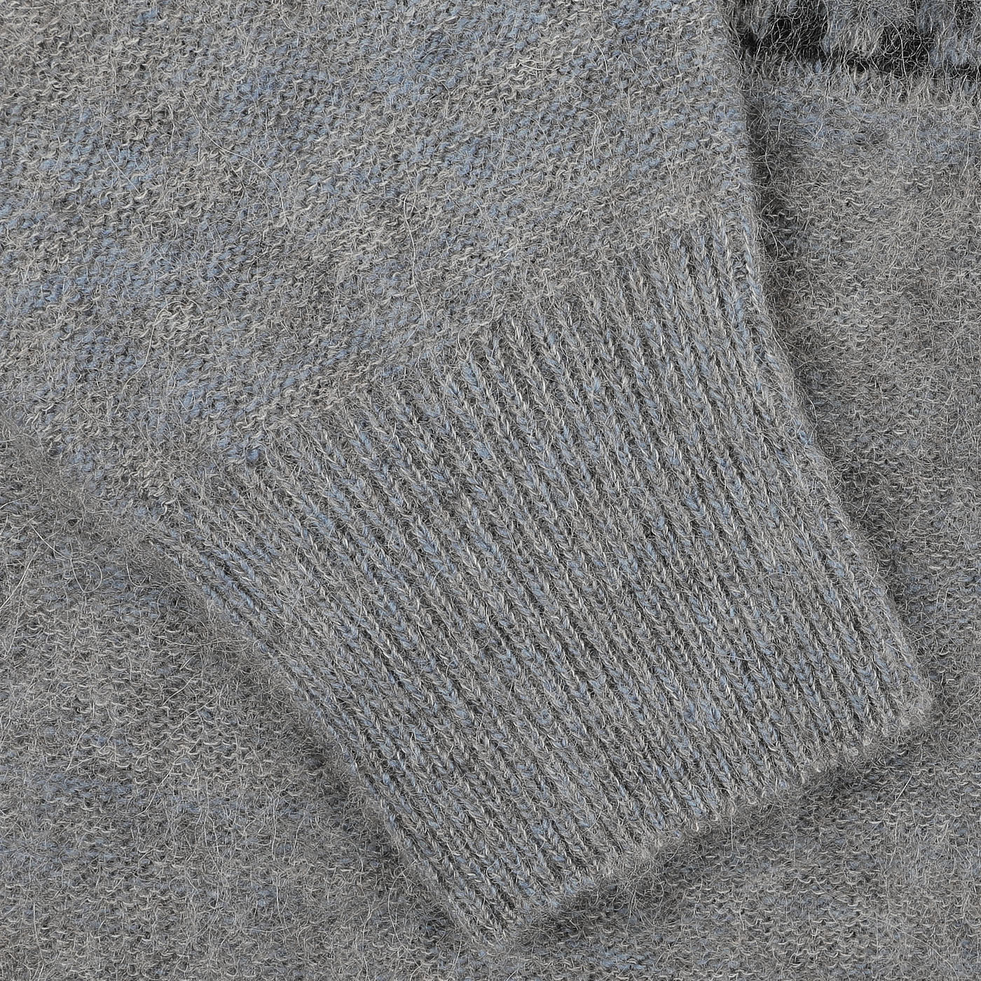 Close-up of a grey melange knitted fabric, highlighting the texture and the cuff of a sleeve from the Altea Grey Melange Norwegian Wool Alpaca Crewneck sweater.