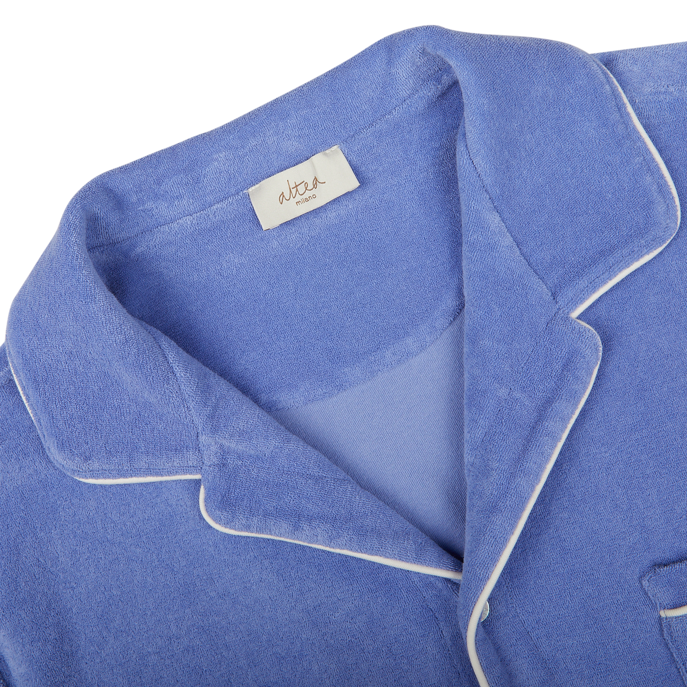 Close-up of a Light Blue Cotton Towelling Capri Collar Shirt made from organic cotton with white piping and a tag with handwriting on the collar by Altea.
