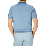 A man seen from behind, wearing a Altea Light Blue Dyed Cotton Capri Collar Polo Shirt and matching trousers against a grey background.