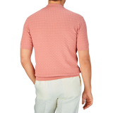 A man standing with his back to the camera wearing a Muted Pink Cotton Capri Collar Polo Shirt by Altea and white pants.
