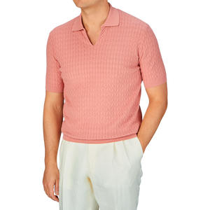 Man wearing a Altea muted pink cotton capri collar polo shirt with a chevronne knit pattern and light-colored trousers.
