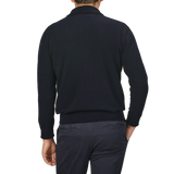 A person wearing an Altea Navy Blue Wool Fleece 1/4 Zip Sweater and dark pants, seen from behind, with their left hand partially visible.