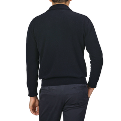 A person wearing an Altea Navy Blue Wool Fleece 1/4 Zip Sweater and dark pants, seen from behind, with their left hand partially visible.