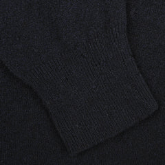 A close-up of a black knitted fabric with a ribbed cuff, part of the Navy Blue Wool Fleece 1/4 Zip Sweater by Altea.