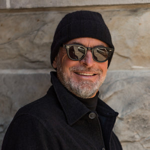 A man wearing sunglasses and an Amanda Christensen Black Wide Ribbed Cashmere Beanie.
