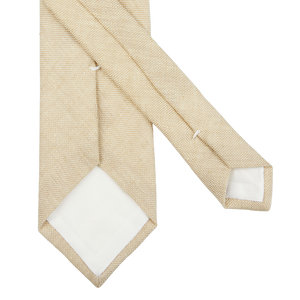 A Light Beige Melange Linen Lined Tie from Amanda Christensen on a white surface.