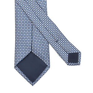 A navy blue micro medallion printed silk lined tie on a white background by Amanda Christensen.