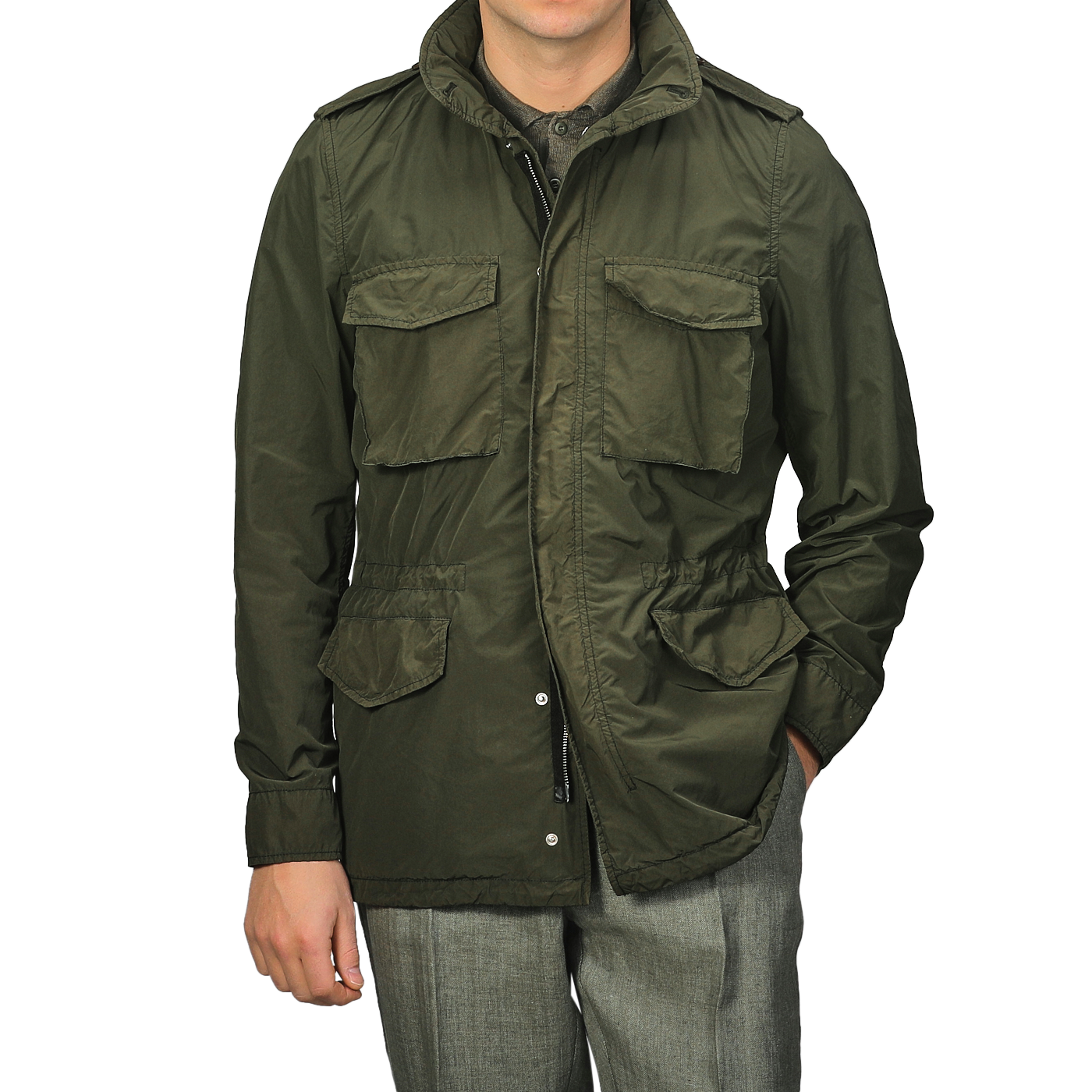 A man wearing an Aspesi Army Green Luxury Nylon Field Jacket with a classic military M65 style, paired with gray trousers.