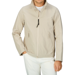 A man wearing an Aspesi Beige Cotton Canvas Windbraker Stringa Jacket and white pants.