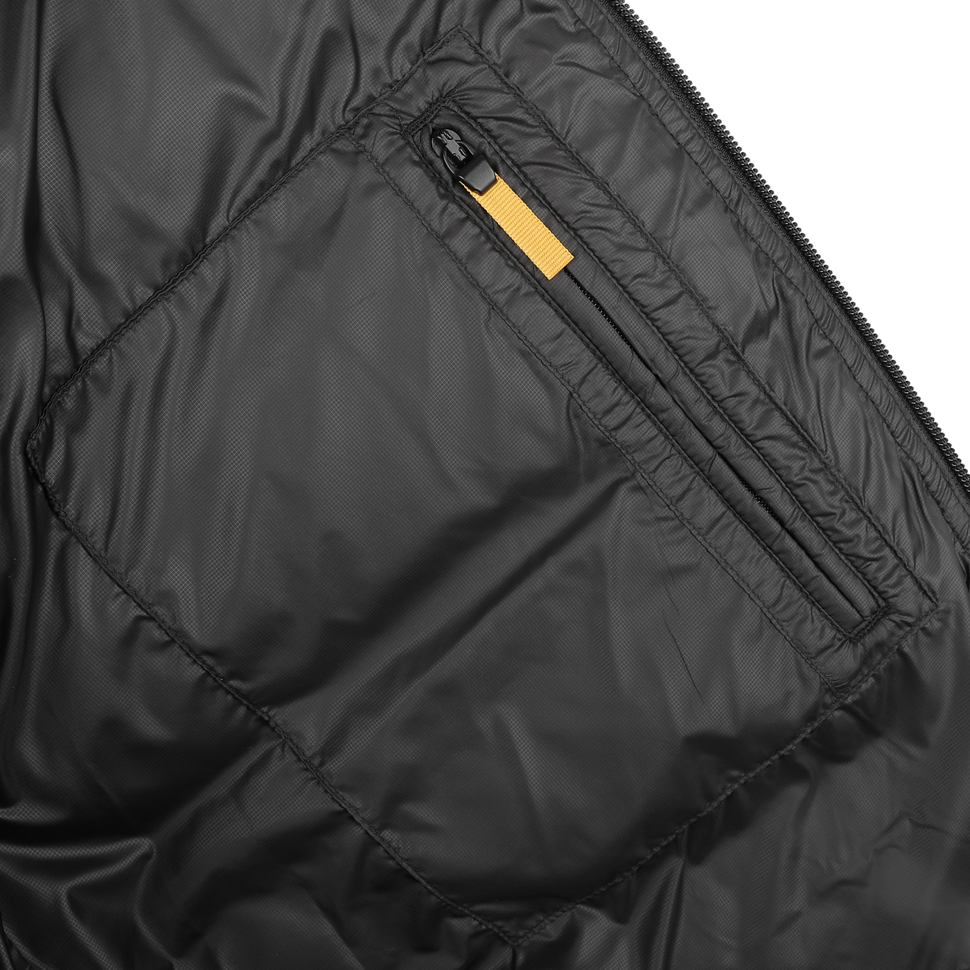 Close-up of an Aspesi Black Nylon Ripstop Down Padded Budd Jacket's zippered pocket with an orange pull tab, highlighting its durable nylon ripstop fabric.