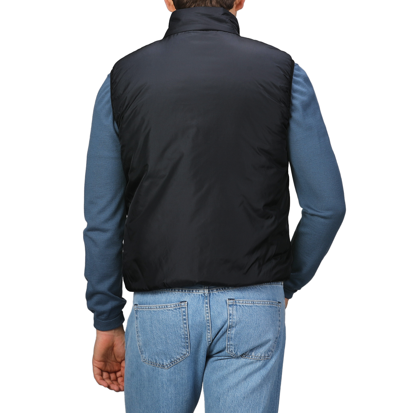 A person is shown from the back wearing an Aspesi Black Nylon Taffeta Thermore Jil Gilet over a blue long-sleeve shirt and denim jeans.