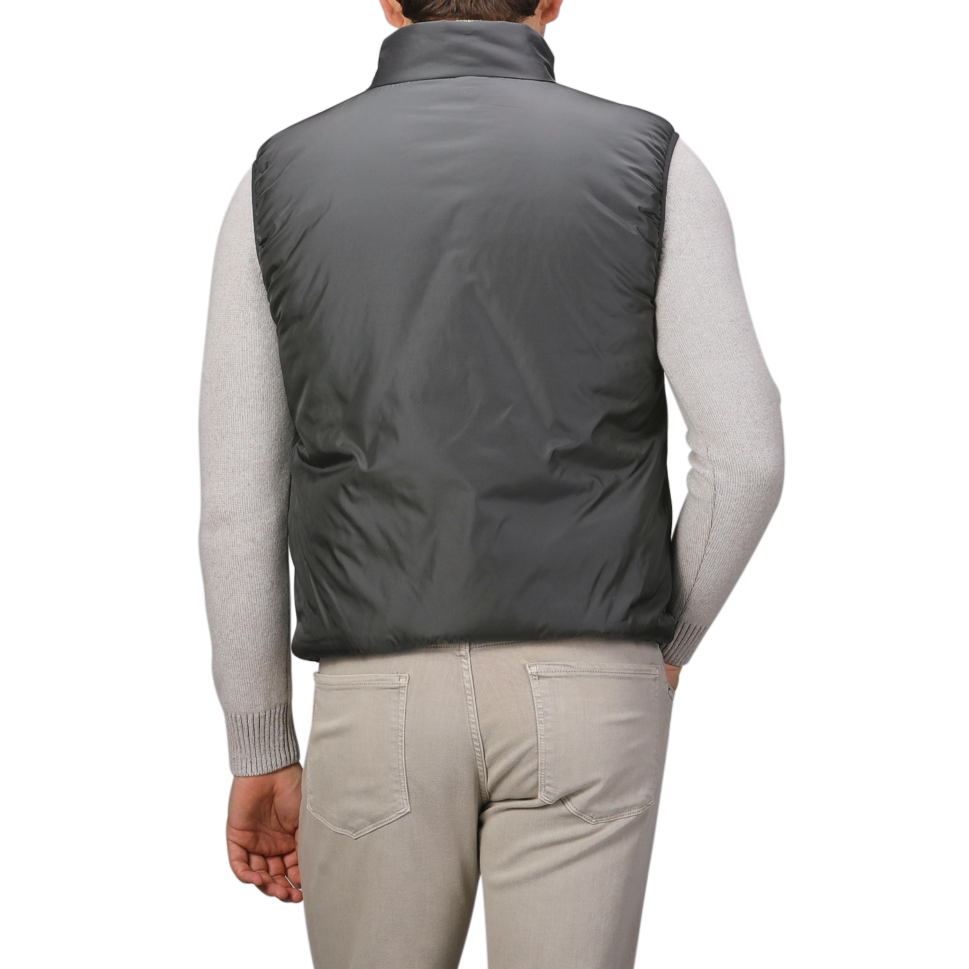 A person seen from the back is dressed in an Aspesi Charcoal Grey Nylon Taffetta Thermore Jil Gilet over a light gray sweater, paired with beige pants.