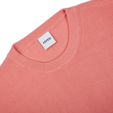 A close up of a Coral Pink Knitted Cotton Sweater by Aspesi with a label on it.