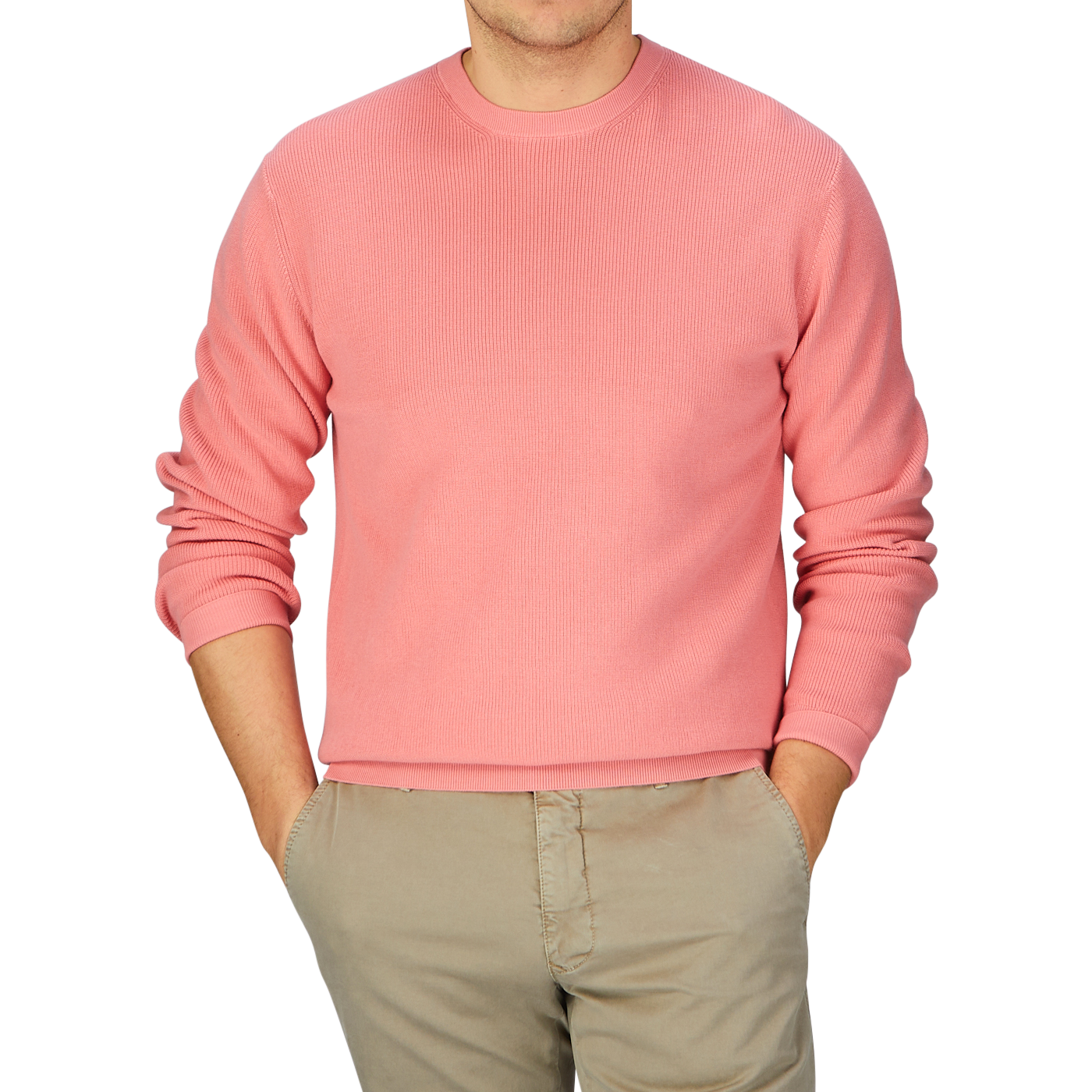 A man wearing a coral pink knitted cotton sweater from Aspesi and khaki pants.