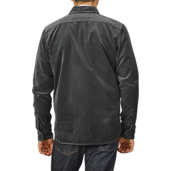 A person wearing an Aspesi Dark Grey Cotton Velvet Overshirt and blue jeans, photographed from the back, standing against a plain light gray background.