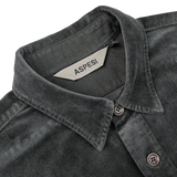 Close-up of the Dark Grey Cotton Velvet Overshirt with a tag inside the collar labeled "Aspesi." This Italian outerwear piece, made from pure cotton velvet, features a button-down collar and visible stitching details.