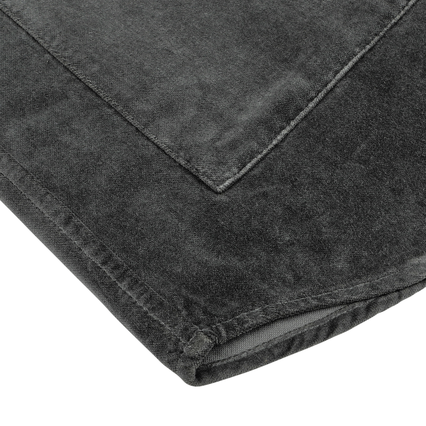 Close-up of a folded Dark Grey Cotton Velvet Overshirt by Aspesi, showcasing its soft, velvety texture on a light gray surface, reminiscent of the luxurious feel often found in Italian outerwear.