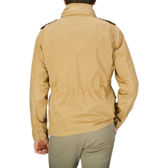 The back view of a man wearing an Aspesi Khaki Beige Cotton Mini Field Jacket, windproof jacket.