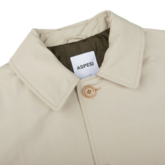 A Light Beige Cotton Thermore Aspesi coat with practical pockets and the word Impermeabile on it.