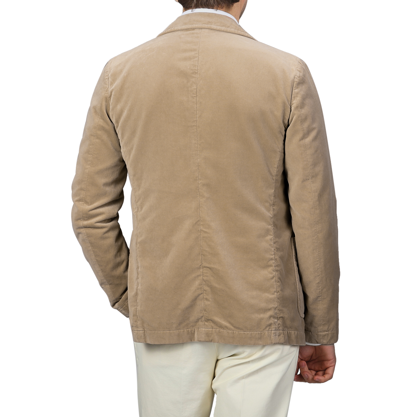 An individual is seen from behind, dressed in the Aspesi Light Beige Cotton Velvet Isaac Blazer paired with white pants, against a gray backdrop.