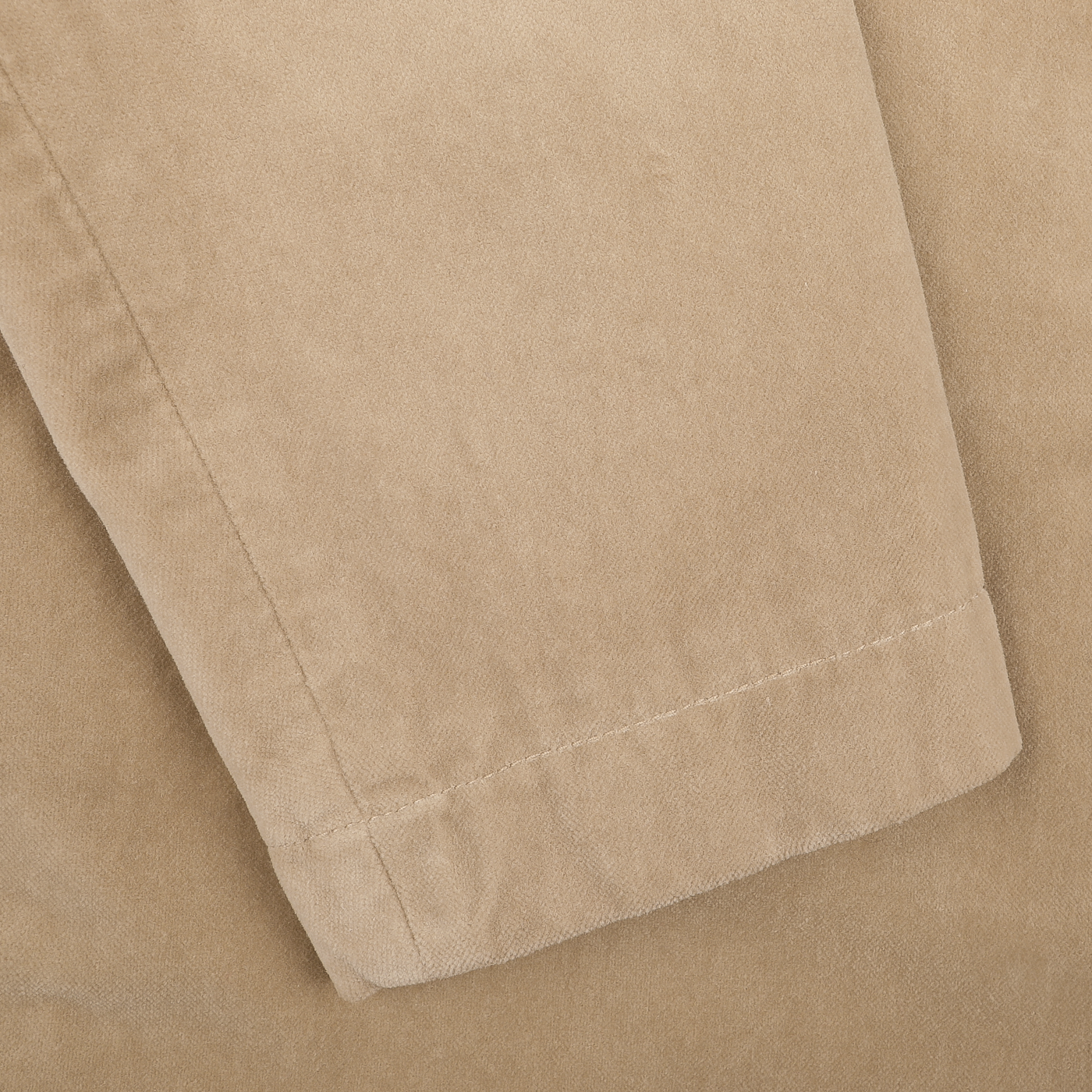 Close-up of a light beige cotton velvet fabric with visible stitching along the edge, reminiscent of the exquisite tailoring found in an Aspesi Light Beige Cotton Velvet Isaac Blazer.