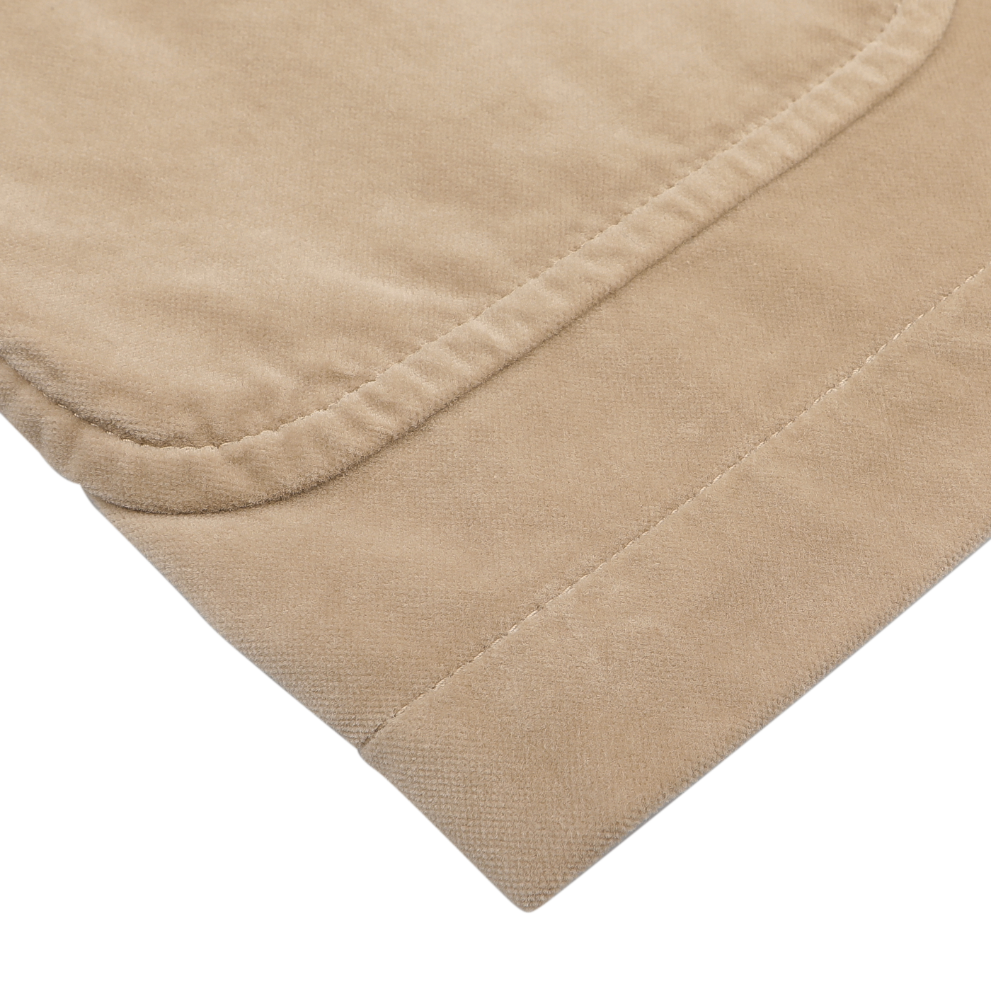 Close-up of a corner of the Light Beige Cotton Velvet Isaac Blazer by Aspesi, showcasing its visible stitching, reminiscent of folded beige khaki fabric, against a plain background.