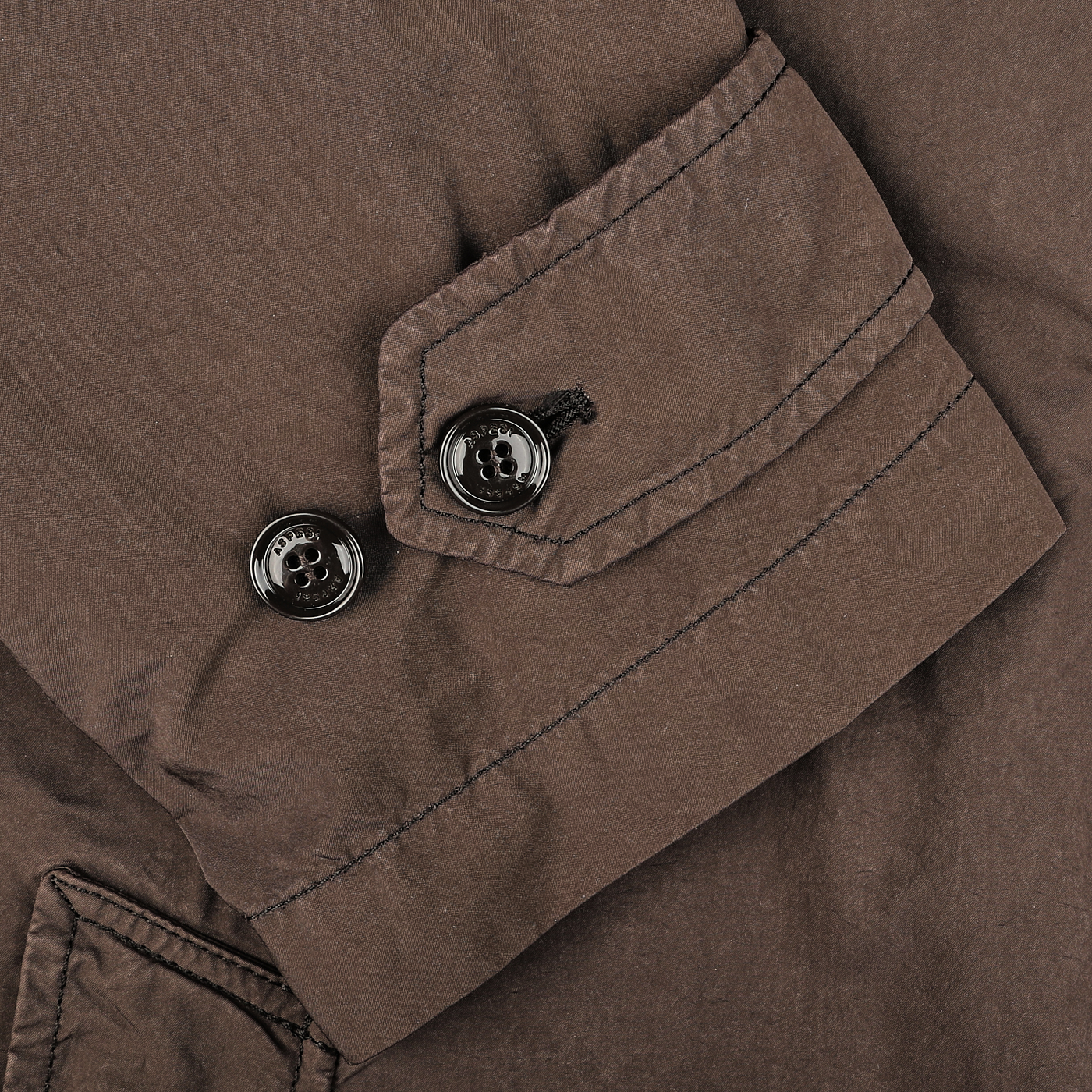 Close-up of a sleeve from the Aspesi Marrone Brown Micro Nylon Thermore Coat, highlighting the detailed stitching, two black buttons, and a small pocket, with Thermore padding for enhanced warmth.