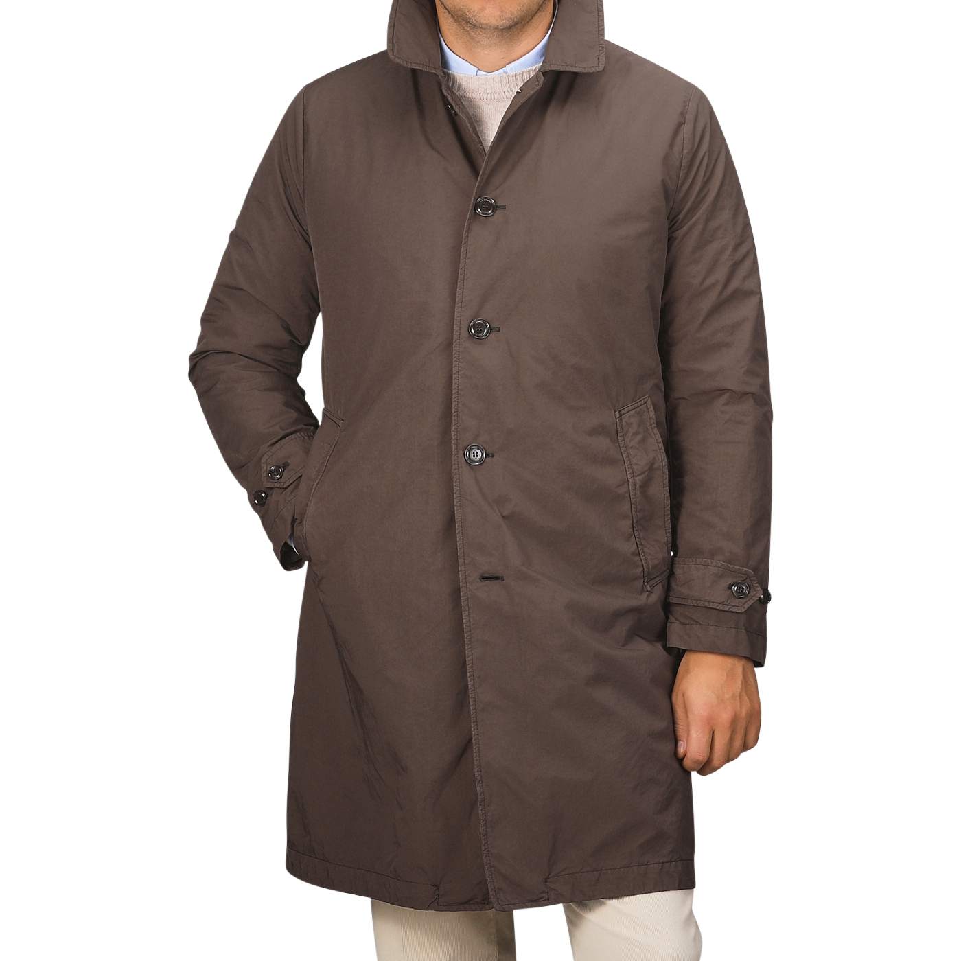 A person wearing a knee-length Marrone Brown Micro Nylon Thermore coat from Aspesi, with buttons and standing with one hand in the pocket.