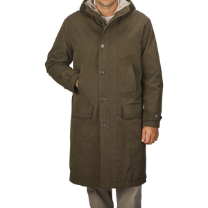 A person wearing an Aspesi Military Green Cotton Nylon Thermore Rams Parka with a hood and four buttons stands against a plain background.