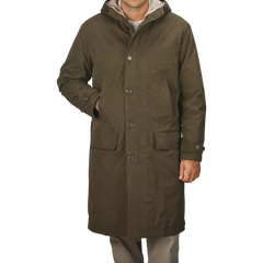 A person wearing an Aspesi Military Green Cotton Nylon Thermore Rams Parka with a hood and four buttons stands against a plain background.