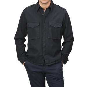 A person wearing the Navy Blue Cotton Twill Field Shirt by Aspesi, characterized by its regular fit and cotton-lyocell blend with two chest pockets, paired with dark pants and hands in pockets.