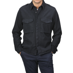 A person wearing the Navy Blue Cotton Twill Field Shirt by Aspesi, characterized by its regular fit and cotton-lyocell blend with two chest pockets, paired with dark pants and hands in pockets.