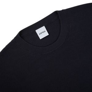 The back of a navy blue knitted cotton sweater with a label on it by Aspesi.