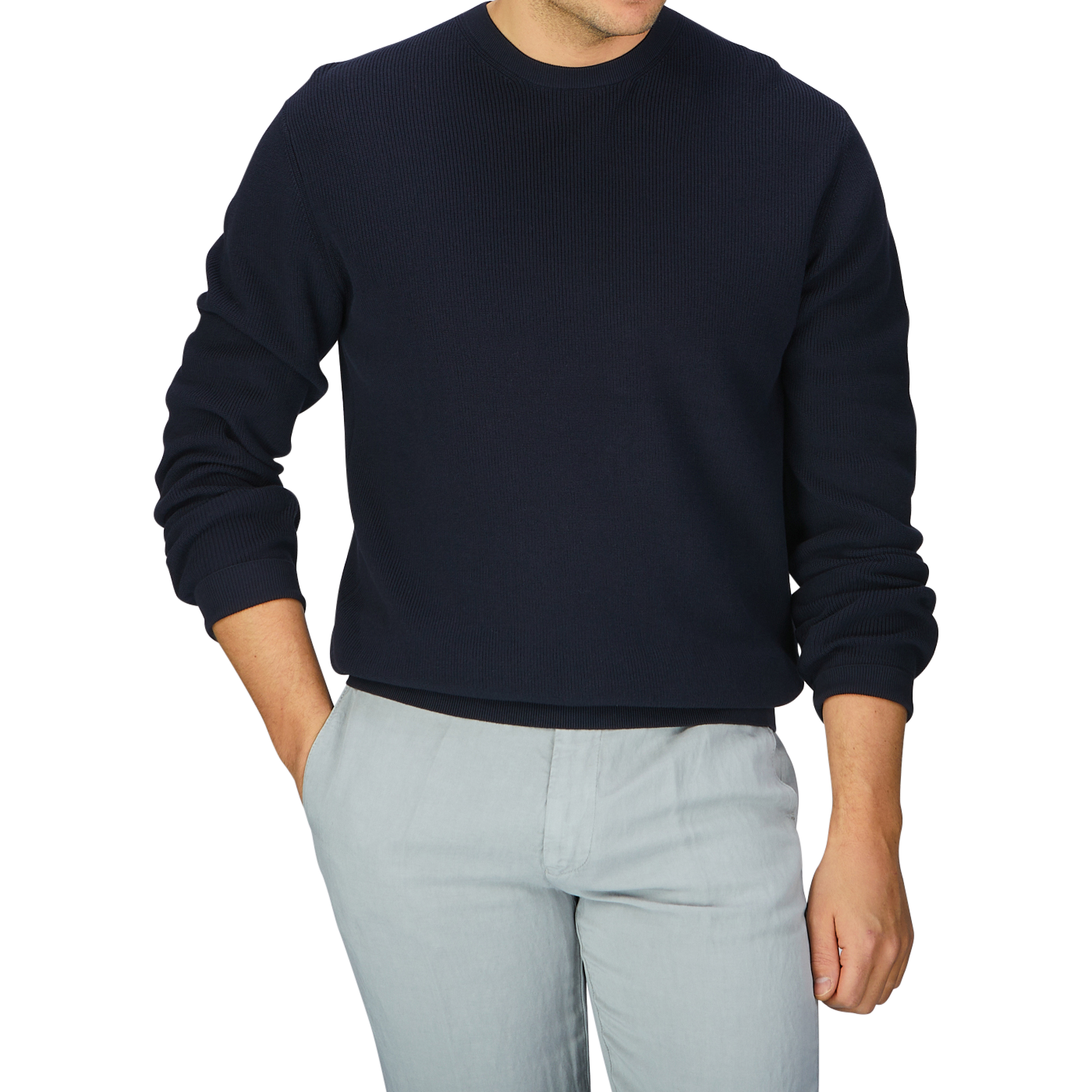 A man wearing an Aspesi navy blue knitted cotton sweater and grey pants.