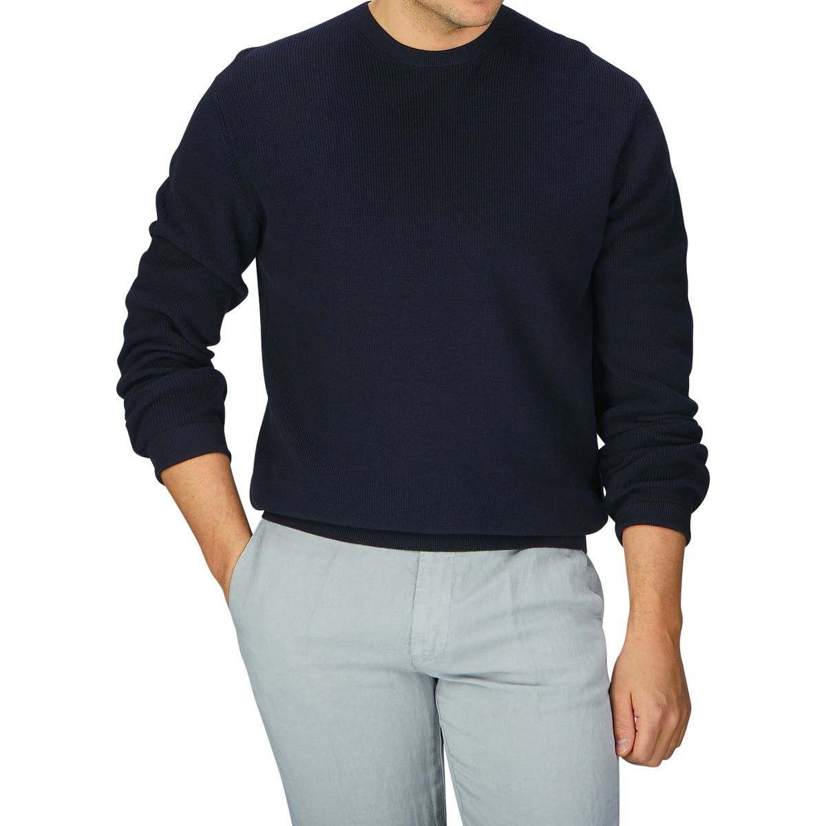 A man wearing an Aspesi navy blue knitted cotton sweater and grey pants.