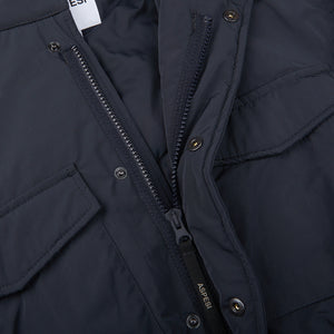 A close up of a navy blue Aspesi Nylon Padded Field Jacket with zippered pockets.