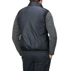 A person wearing an Aspesi Navy Blue Nylon Taffetta Thermore Jil Gilet over a gray sweater and dark pants, viewed from the back.