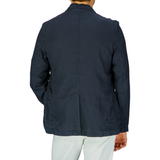 A person seen from the back wearing an unstructured, Aspesi Navy Blue Washed Linen Samuraki Jacket and white pants.