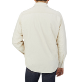 The back view of a man wearing a cream Aspesi Off-White Cotton Padded Overshirt.